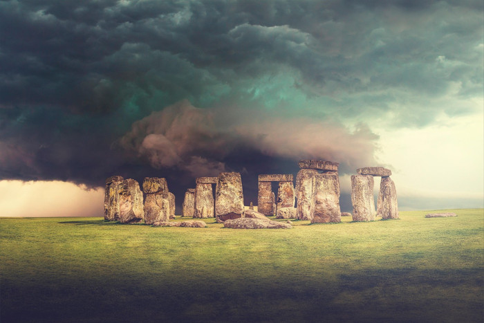 A moody, dramatic shot of ancient stone monoliths under a stormy sky (Stonehenge style). 