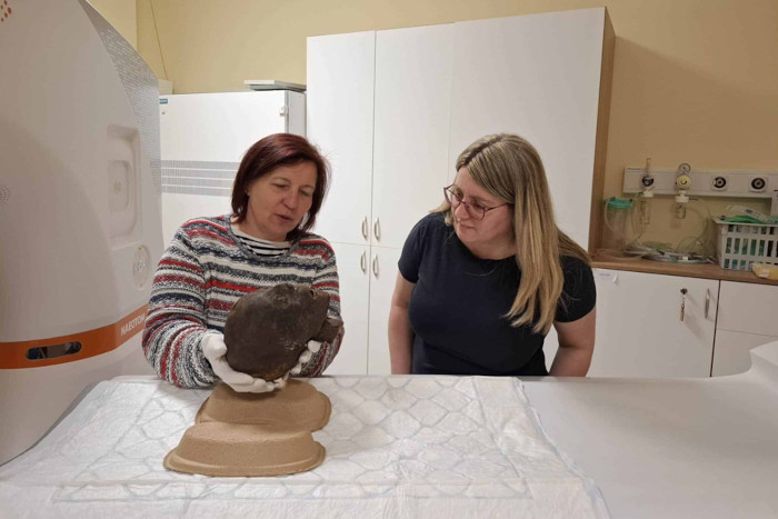 Krisztina Scheffer and Dr. Ibolyka Dudás holding the mummified head of an Egyptian woman
