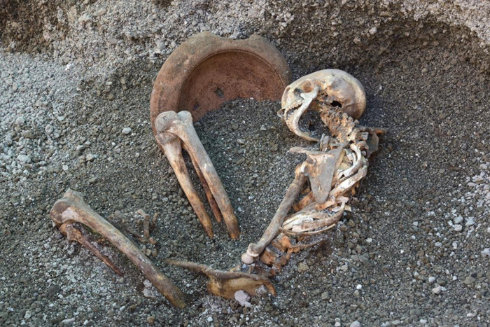 The victims skeleton, beside a terracotta mortar.