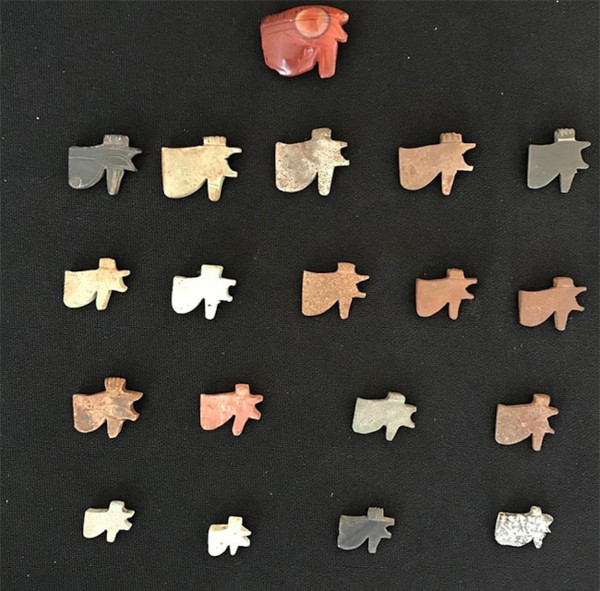 A collection of Tyet (Isis Knot) amulets and other protective charms
