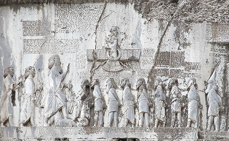 Relief sculpture from the Behistun Inscription showing King Darius I with captives beneath the winged symbol commonly associated with Ahura Mazda