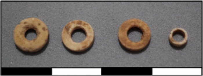 Four annular beads made from ostrich eggshell