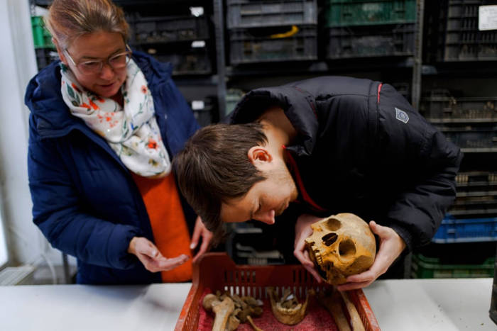 Lead archaeologist Gabriella Fényes and specialist Gergely Kostyal examining skeletal remains 