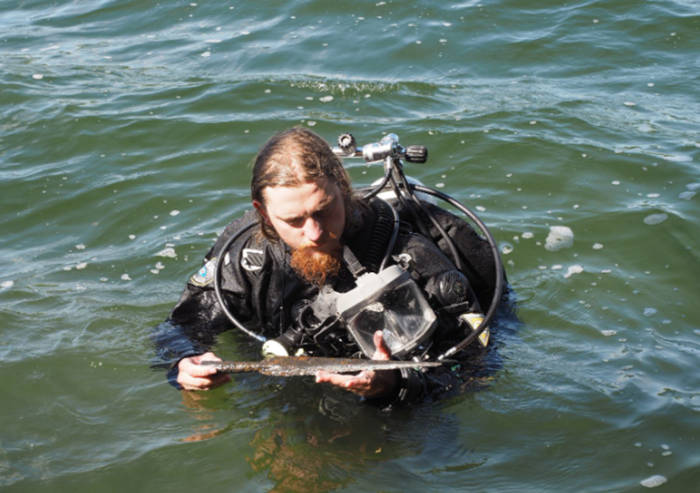 Underwater archaeologist with a spearhead find.