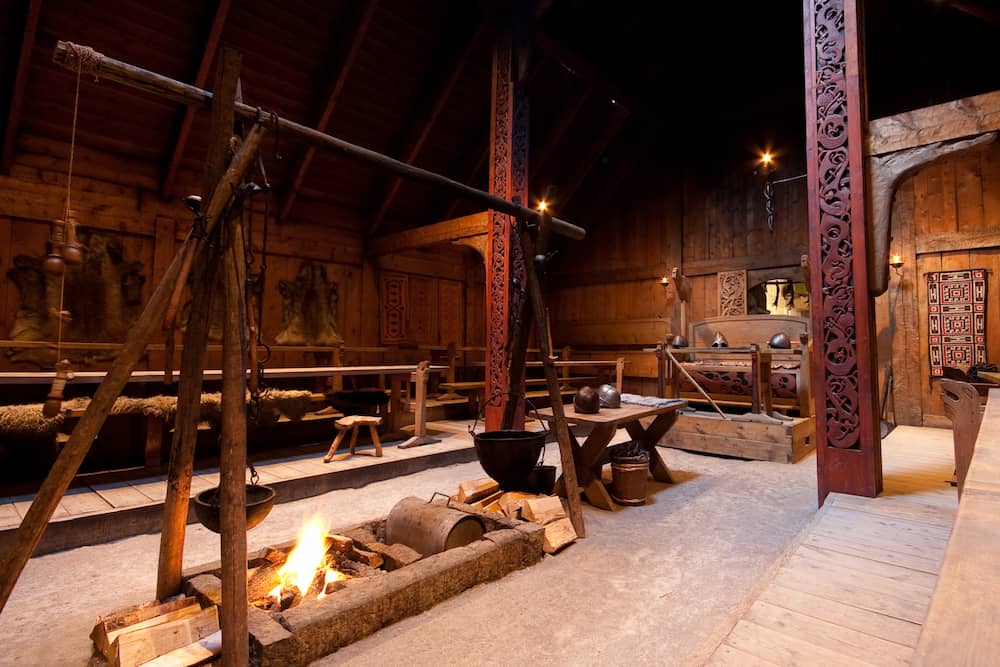 Interior of the reconstructed Viking Age chieftain's hall (longhouse) at the Lofotr Viking Museum in Borg, Norway. This reconstruction represents the massive high-status farmsteads that defined the "Hall Culture" following the mid-6th-century crisis.