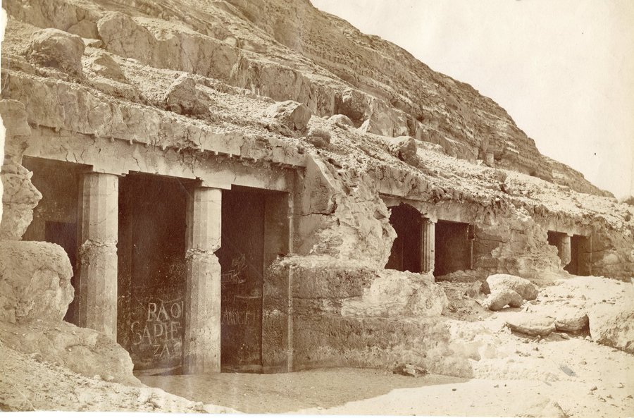 Nineteenth-century photograph of columned tomb entrances cut into a desert cliff