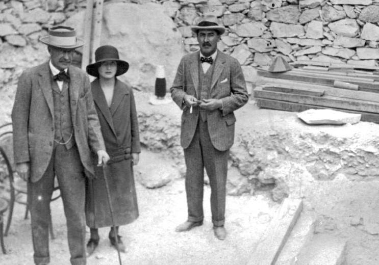 Black and white photo of Howard Carter, Lord Carnarvon and Lady Evelyn Herbert standing by stone steps in the Valley of the Kings