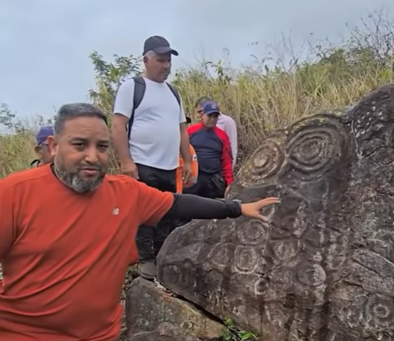 Authorities examining the rock where the petroglyphs have been discovered.