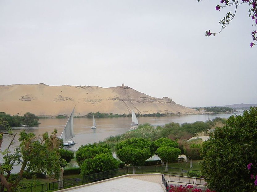 Qubbet el-Hawa and the Nile, viewed from the Aswan Botanical Garden, with the tombs and Coptic church site visible on the slope