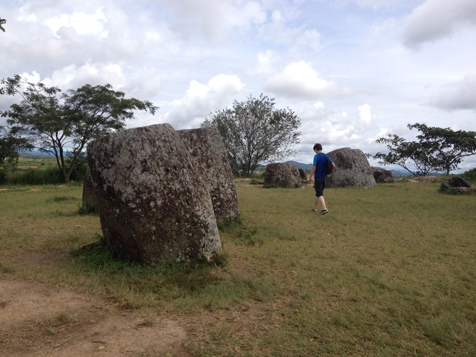 A large stone jar with a person for scale at the Plain of Jars, Phonsavan, Laos 