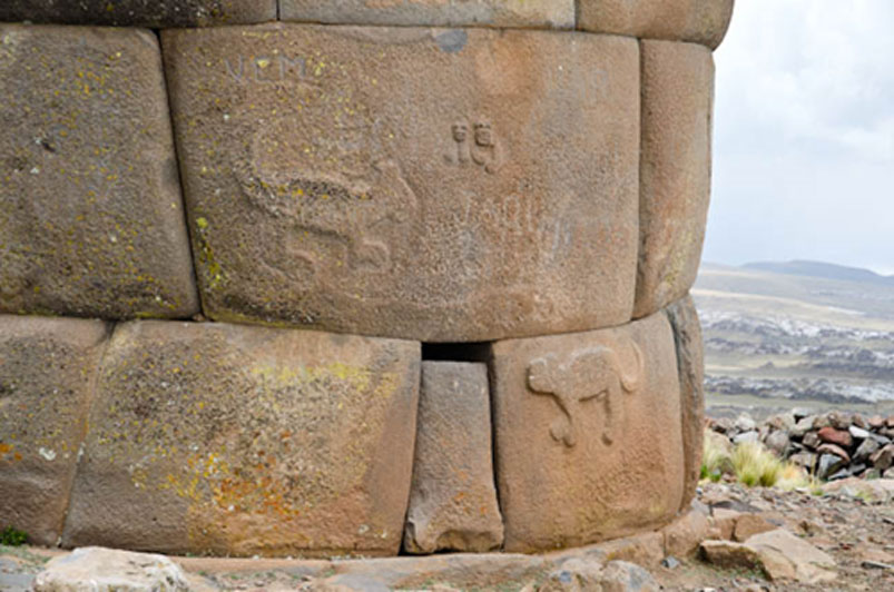 Close-up of the carved reliefs of two dogs and the initiate coupled with his divine bride