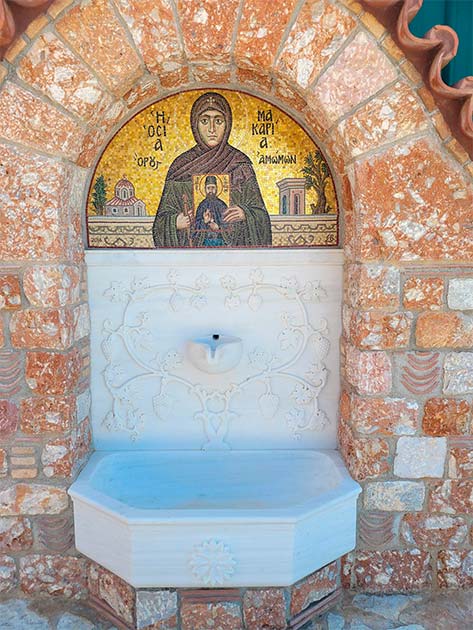 A mosaic above a water fountain depicts Sister Makaria holding an image of Saint Ephraim. Photo: Joanna Gillan