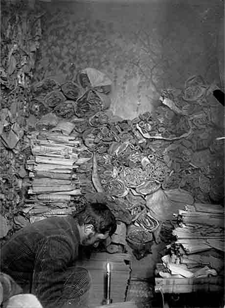 Paul Pelliot examining the Dunhuang manuscripts in the Library Cave at the Mogao Caves of Dunhuang, China, in 1908. (Public domain)