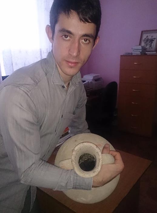 One of the researchers holding the Greek amphora.