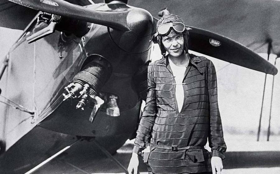 Amelia Earhart standing outside of her airplane after landing it. 
