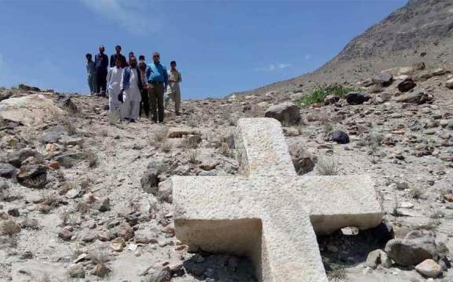 A group of locals posing with the ancient cross in Pakistan.    Source: Pamir Times