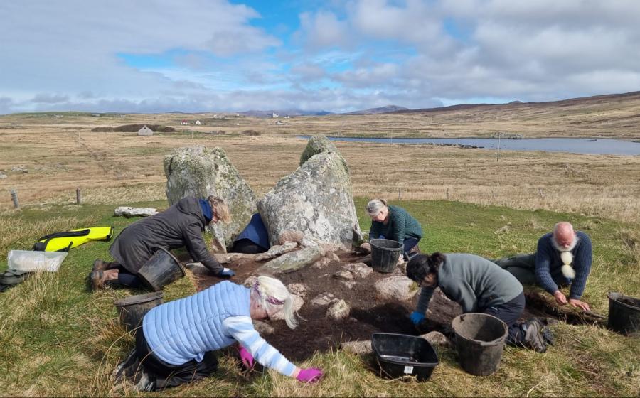 Archaeologists and community volunteers excavate around the surviving upright stones of the Leaval chambered cairn