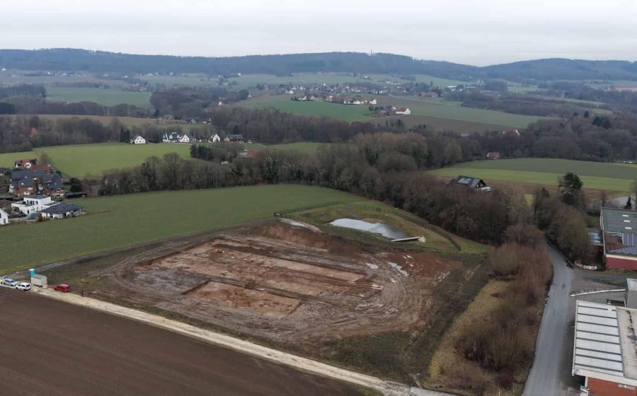 Aerial view of the excavation site for the new fire station on Lohagenweg in Hüllhorst. The line of trees marks the course of the spring stream that once provided the foundation for the original farmstead.  Photo: LWL-AfW / A. Koch