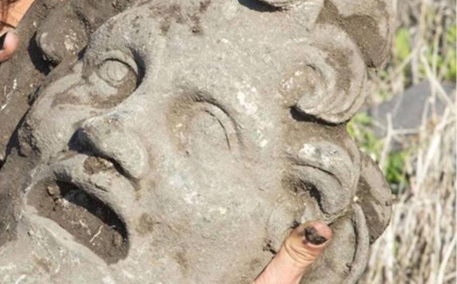 A University of Haifa researcher holds the unique bronze mask of the god Pan 