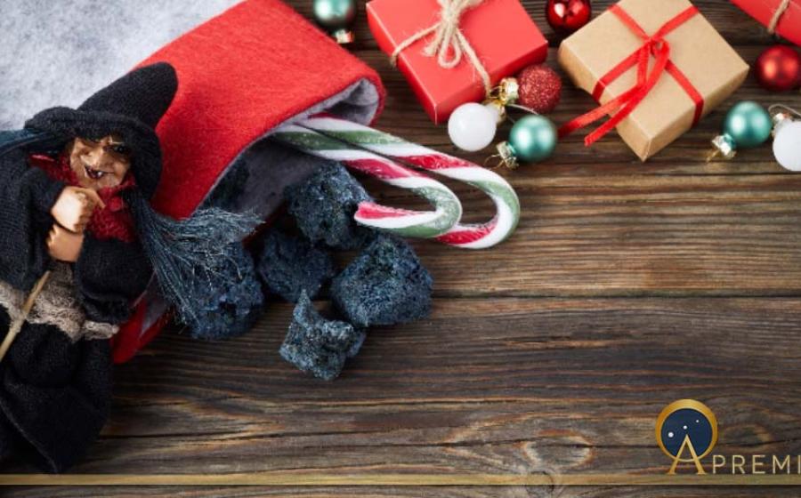 The Befana with sweet coal and candy on wooden background. Italian Epiphany day tradition (vetre/Adobe Stock)