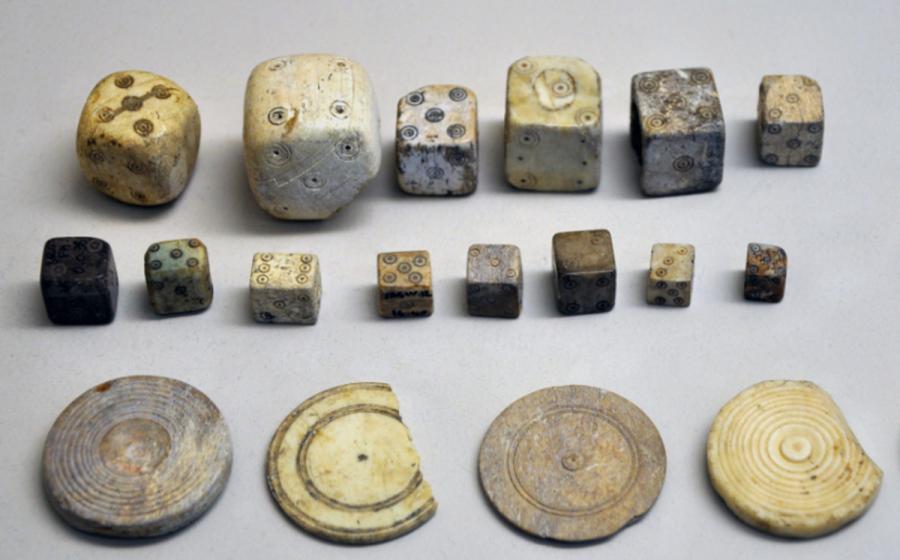 A collection of Roman bone dice and gaming counters from the Gallo-Roman Museum of Saint-Romain-en-Gal, France