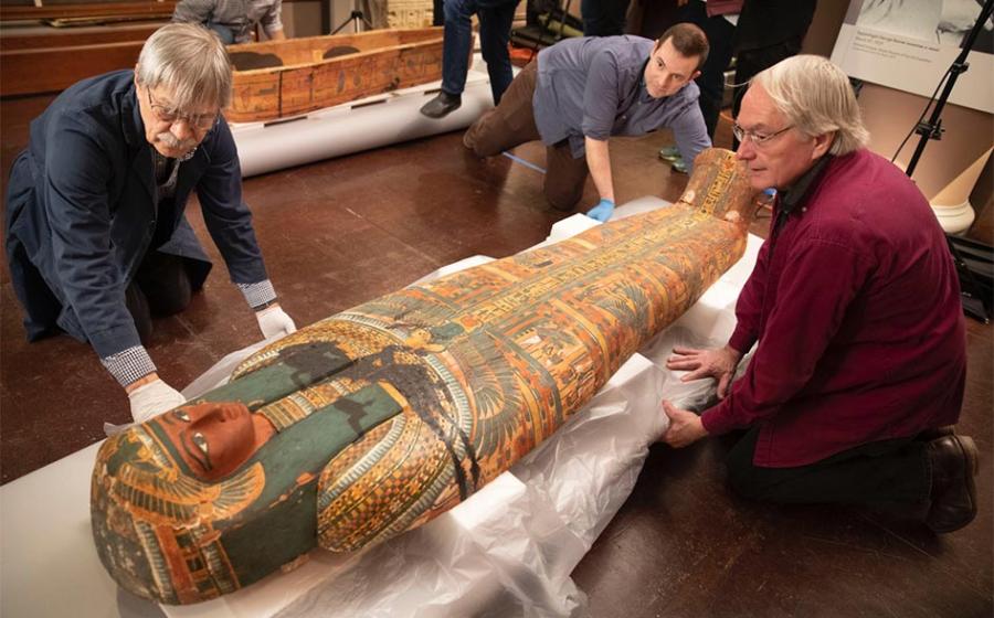Dennis Piechota (from left), Adam Middleton, and Joe Green work on the ancient Egyptian coffin of Ankh-Khonsu with a team at the Semitic Museum. Source: Kris Snibbe / Harvard Gazette.