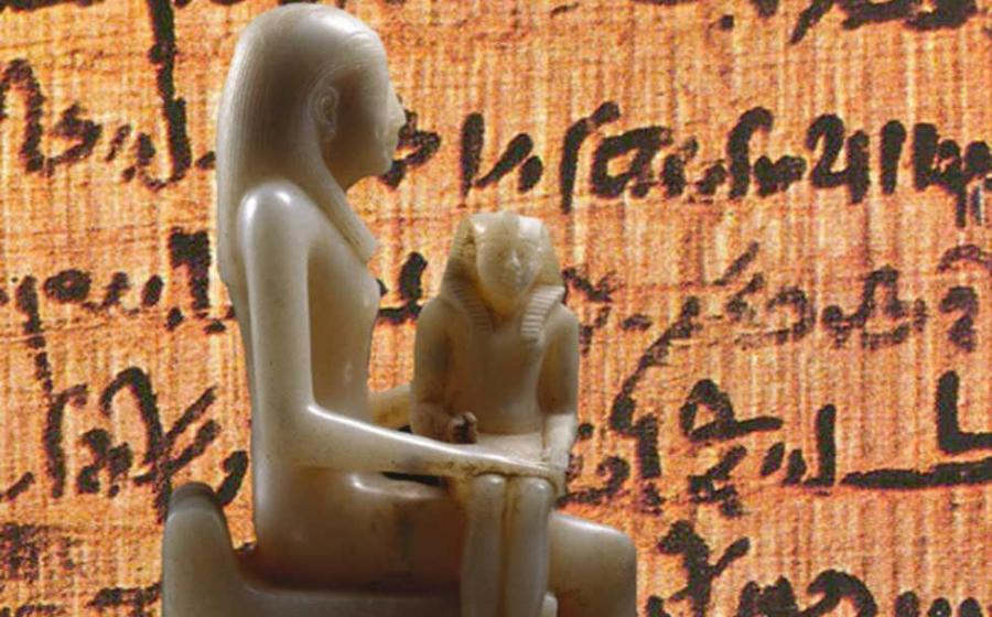 Statue of Queen Ankhnes-meryre II and Her Son, Pepy II. (Brooklyn Museum) Background: Papyrus with ancient Egyptian writing.
