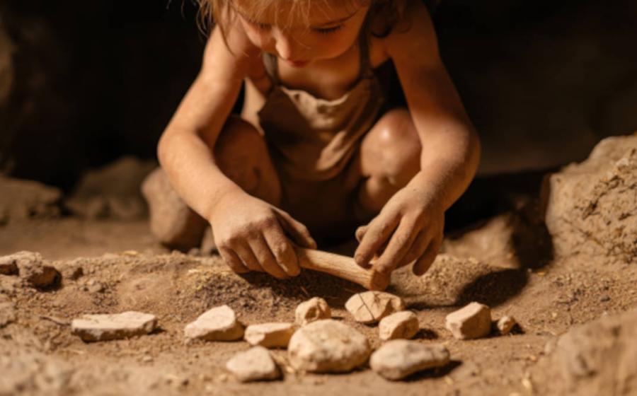 Representative image of Neanderthal child playing with a collection of stones.