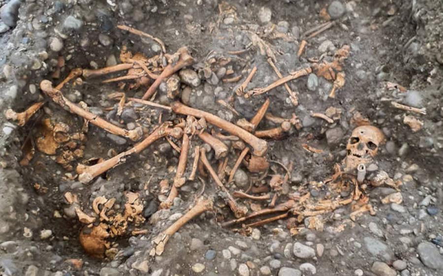 Multiple individuals buried in a pit by the gallows. 