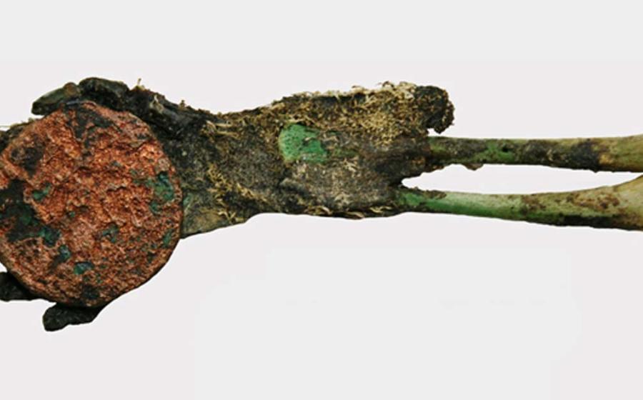 The baby had been partially mummified and had green bones due to copper from a coin placed in its hand.