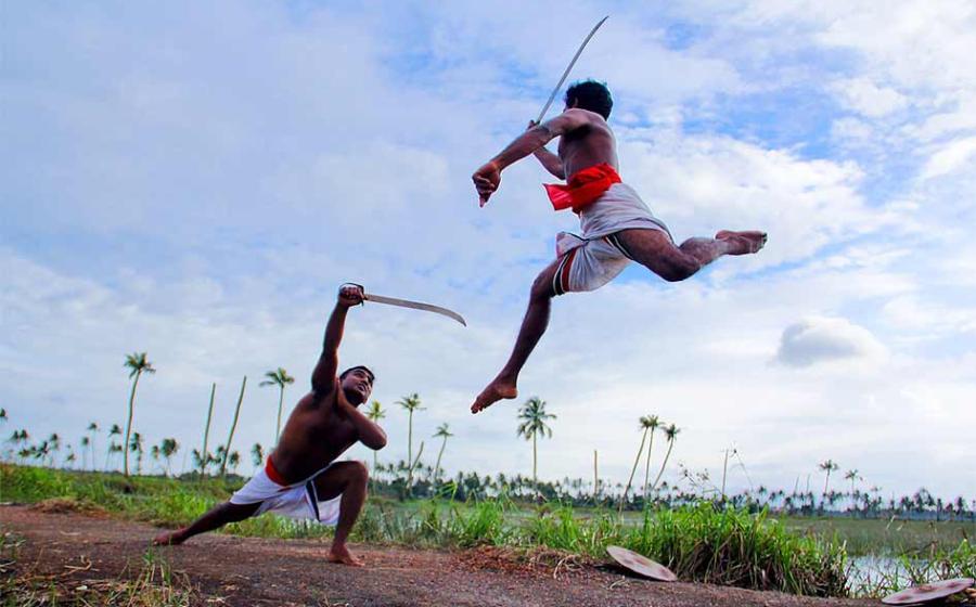Two Kalaripayattu swordsmen in mock sword against sword combat in Kerala. This Indian martial art is still very much alive today!