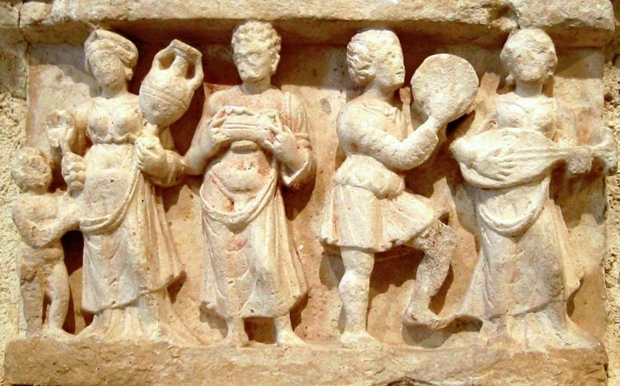 Hellenistic culture in the Indian subcontinent: Greek clothes, amphoras, win,e and music. Detail from Chakhil-i-Ghoundi Stupa, Hadda, Gandhara, 1st century AD. 