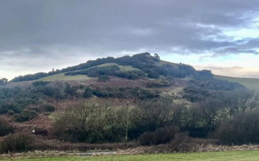 A grassy coastal mound in Cumbria believed by archaeologist Steve Dickinson to be “The King’s Mound,” potentially covering a Viking ship burial. 