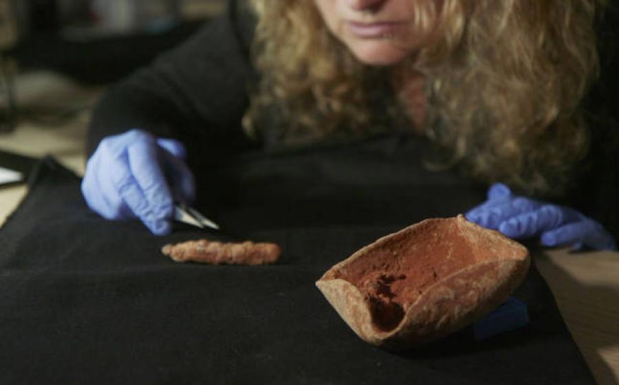 Dr. Naama Sukenik examining the ancient lamp wick