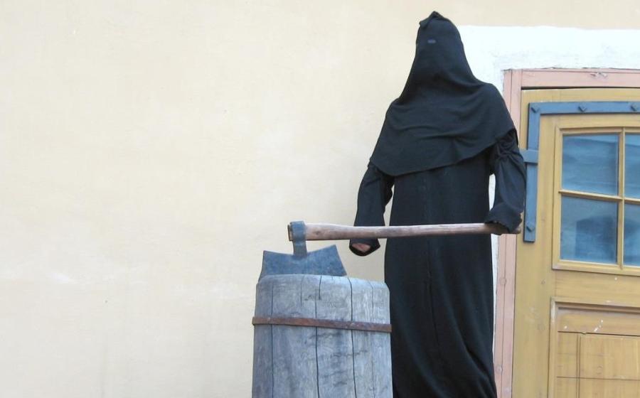 A medieval executioner with executiners ax and block.