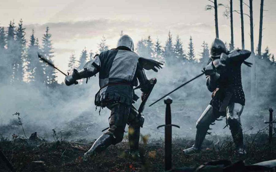 Reenactment of two Armored Medieval Knights Fighting with Swords. Source: Gorodenkoff/Adobe Stock