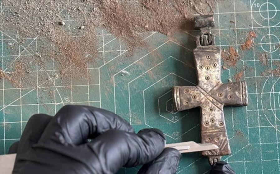 A conservator applies delicate conservation work to the intact, permanently sealed bronze reliquary cross found at Lystra.