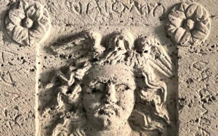 Burial urn with Medusa relief and Etruscan inscription.