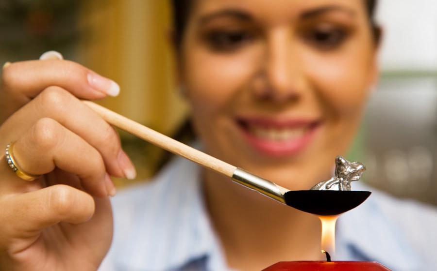 Woman practicing molybdomancy for New Year’s Eve. (Source: Gina Sanders / Adobe Stock