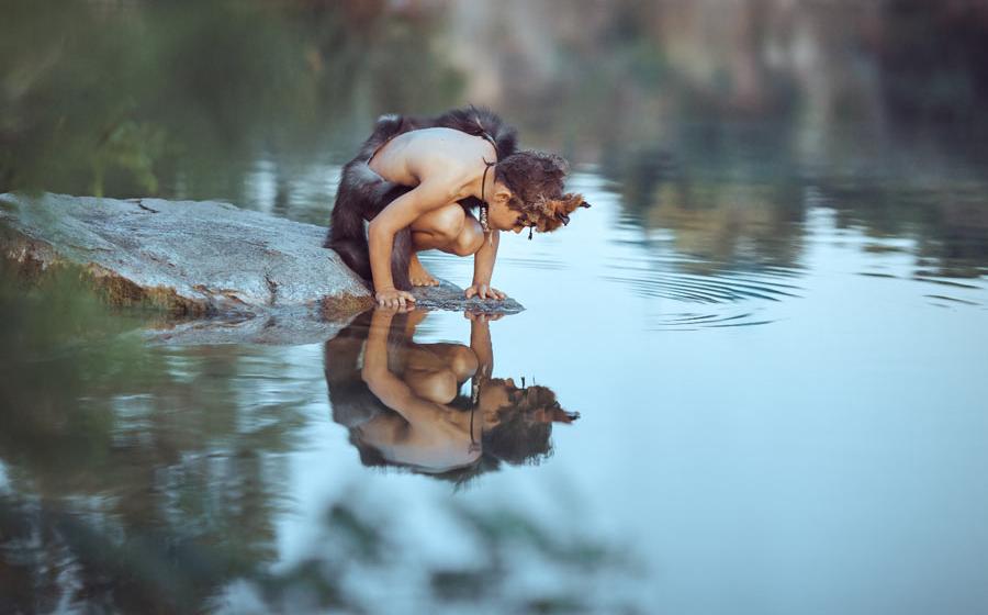 A Neanderthal boy looking at his reflection not knowing that Neanderthal development was faster than that of modern humans. Some kids have it easier!		Source: EmotionPhoto / Adobe Stock