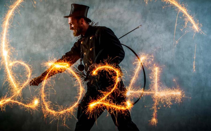 Chimney sweep in work clothes writes the year 2024 with sparklers. Source: Werner/Adobe Stock