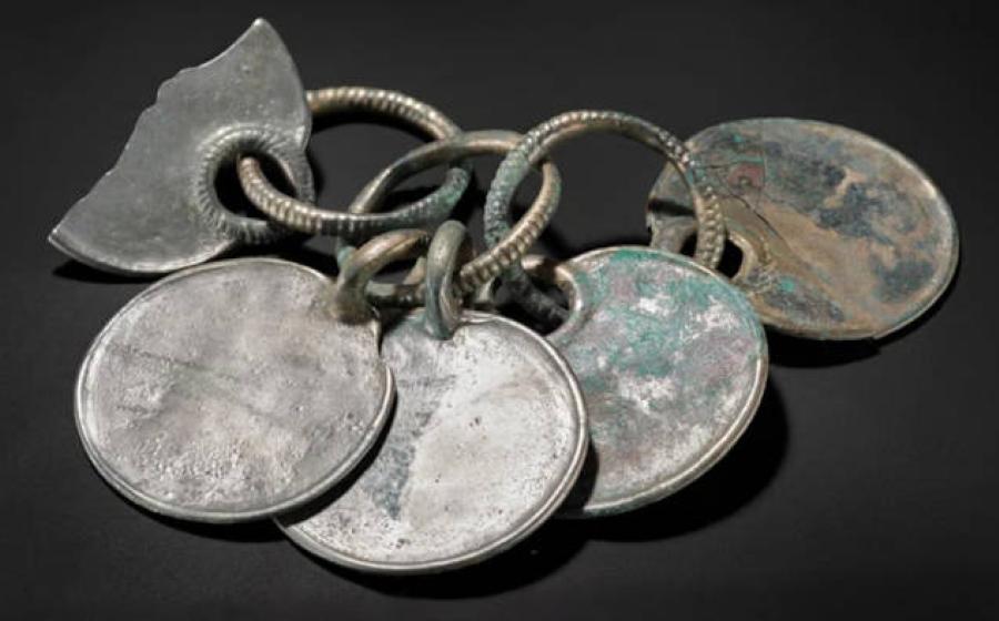 Item described as a Bronze rattle pendant from the Peebles hoard.