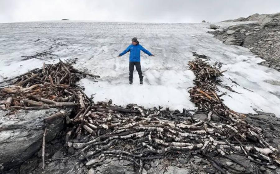Researcher at the site of a pile of logs at the edge of the iceflow, which were used to construct the reindeer trap.