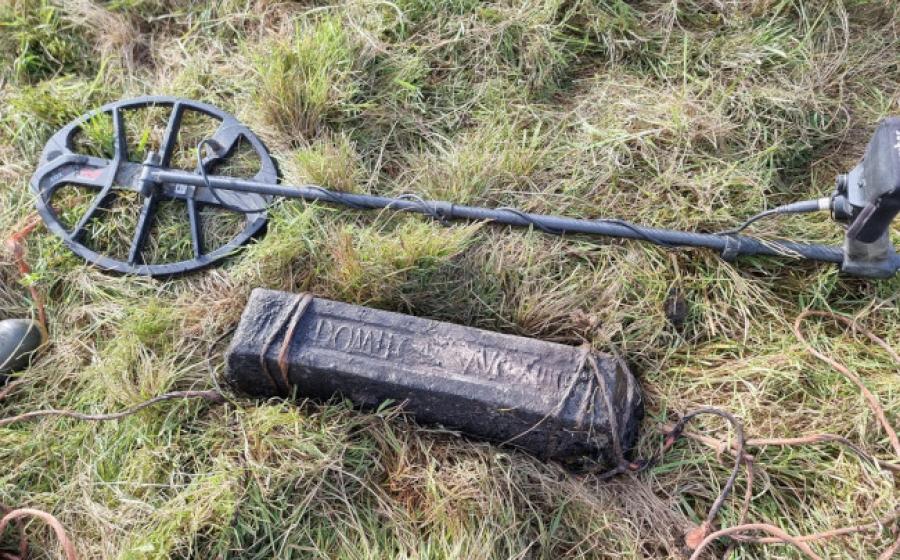 A lead ingot near the find site, with the metal detector that found it.