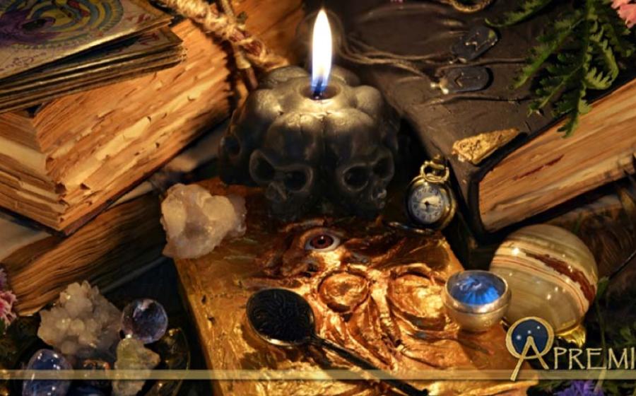 Ancient Sorcery: Antique witch book, black candle and ritual objects.