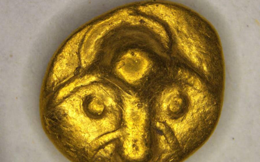 The obverse of the 2,200-year-old Celtic gold quarter stater showing a stylized animal head, possibly a stag
