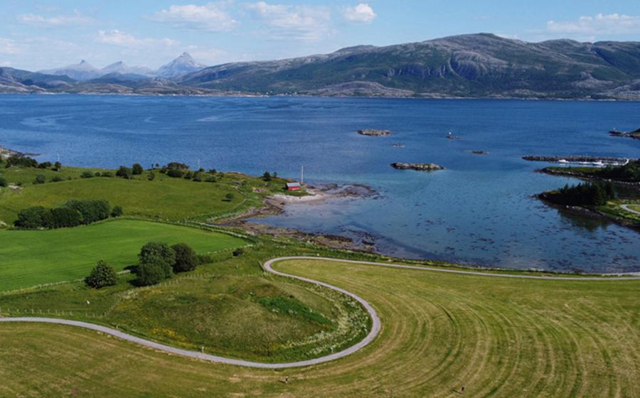 Herlaugshaugen (in the center foreground) from the west, looking towards the strait and the mainland in the background