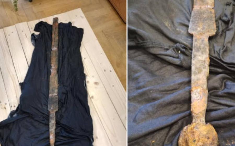 Two views of the medieval sword recovered from the Vistula River in Warsaw, displaying characteristic features including a spherical pommel and cross marking on the handle. 