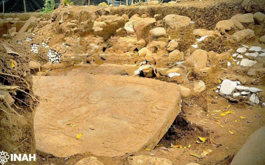A large carved monolithic sculpture slab in the excavation trench, Coatepec, Veracruz.