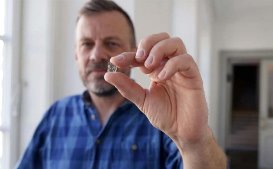 Senior Researcher at the National Museum of Denmark Mads Dengso Jessen holds a Viking Age window glass fragment. Source: John Fhær Engedal Nissen / National Museum of Denmark